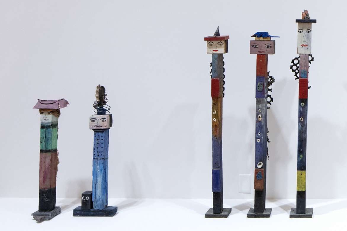 Five wooden sculptures of varying height.