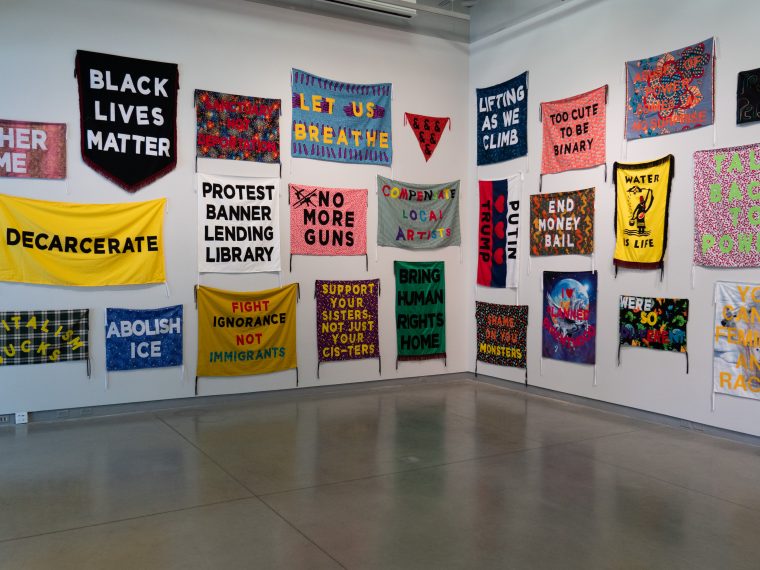 Installation view of Aram Han Sifuentes’ “Protest Banner Lending Library” (2016–present) in her solo exhibition “We Are Never Never Other,” curated by Kendra Paitz and on view at University Galleries of Illinois State University from August 15 through October 13, 2019. Photo credit: Jessica Bingham.
