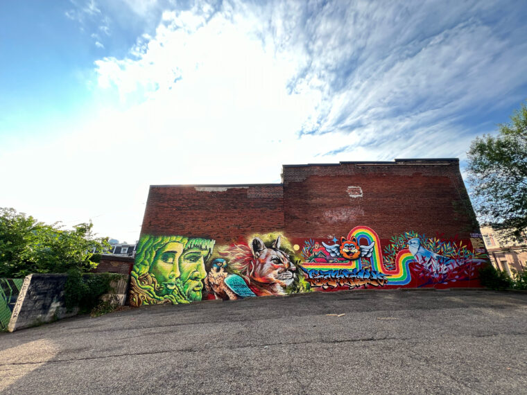 Tikay, Dakpak de la Selva, Melon James, Pilster and Gonzales mural on Penn Avenue.  June 2024. (Pittsburgh, PA). Spraypaint and acrylic paint on brick. Approx 20 by 100 feet. Curated by Hemispheric Conversations Urban Art Project Visiting Artist Residency. Photo credit: Shane Pilster.