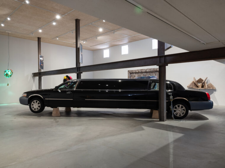 Cameron Patricia Downey, Pleaser, 2024. Stretched Lincoln town car, Jill Scott jack stand, two channel video (4:48 min loop). 28 x 118 x 64 inches. © Midway Contemporary Art; photos by Caylon Hackwith