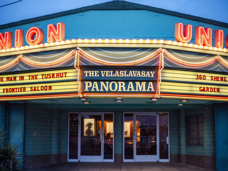 Exterior façade and neon marquee of the Velaslavasay Panorama announcing The Man in the Tuskhut. Image credit: Forest Casey.